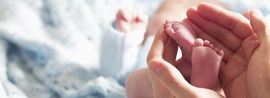 Infant feet in a mother's hands