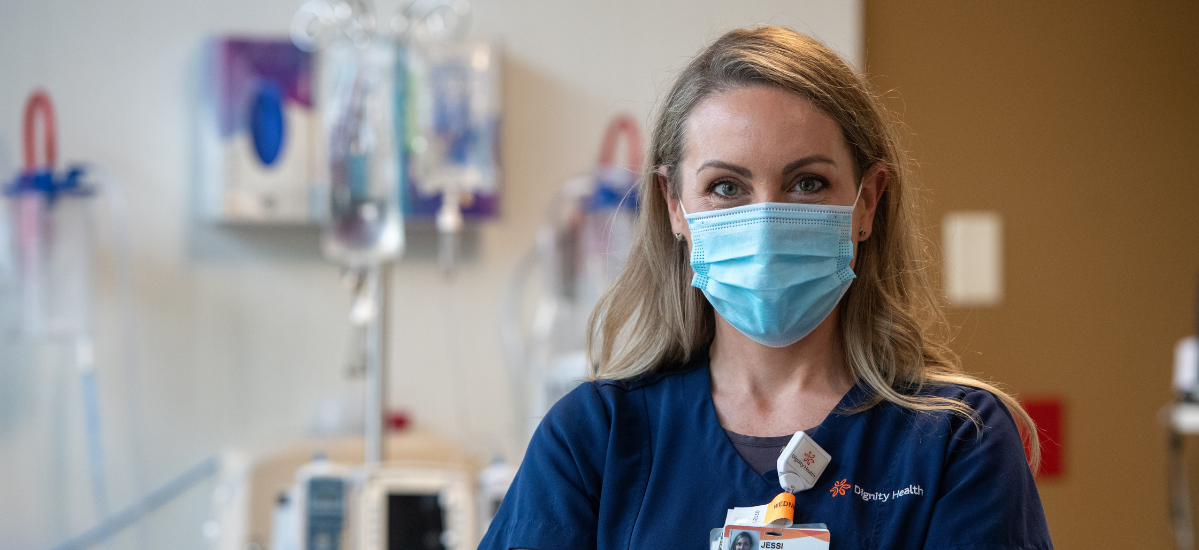 Portrait of a young, female French Hospital nurse in mask standing in a patient room Portrait of a young, female French Hospital nurse in mask standing in a patient room