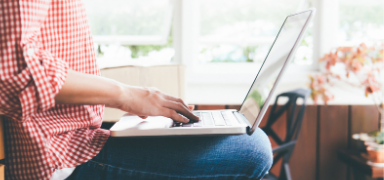 Person typing on their laptop in their lap.