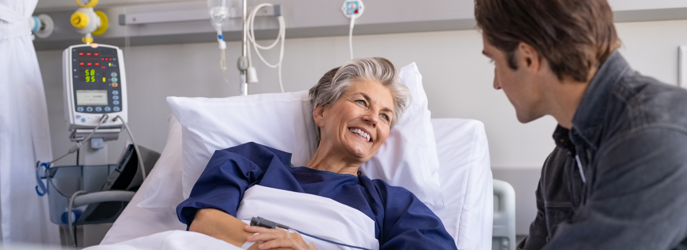 Smiling female patient in a hospital bed talking to a visitor Smiling female patient in a hospital bed talking to a visitor