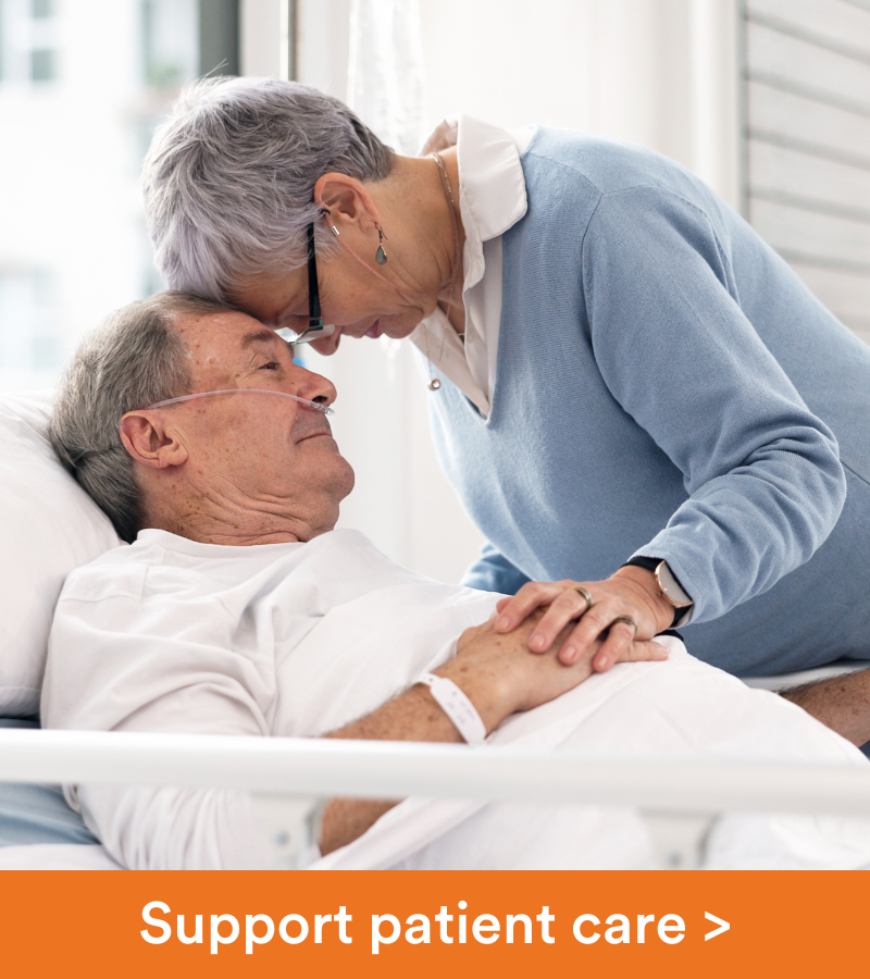 A wife touches her forehead to her husband's, who is in a hospital bed.Copy reads "Support our patients".