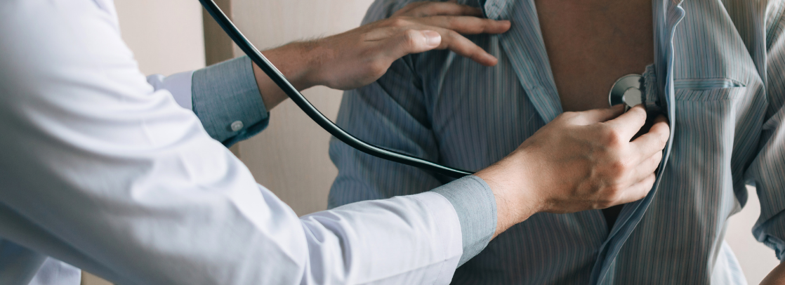 A physician listens to a patient's heart with a stethoscope