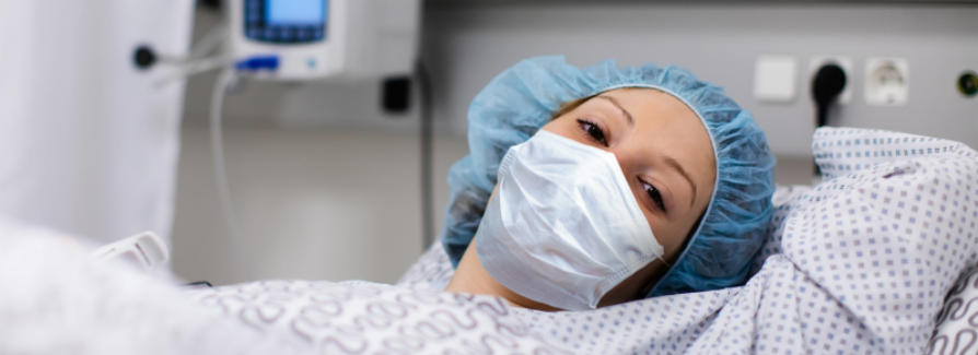 Portrait of a female hospital patient in a hospital bed, wearing a mask Portrait of a female hospital patient in a hospital bed, wearing a mask