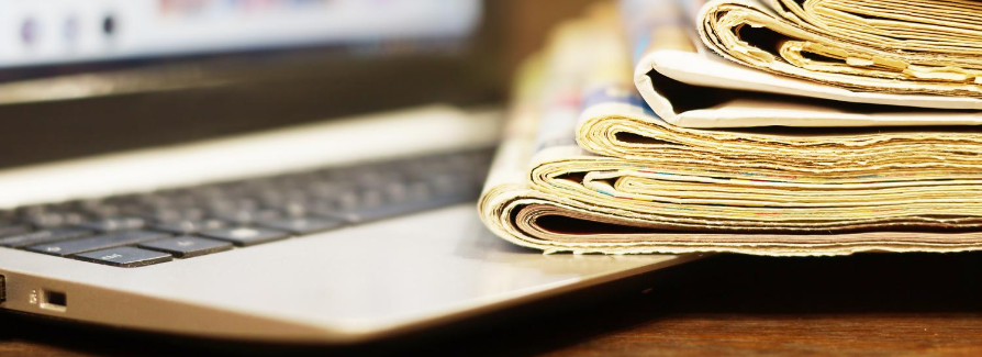 Newspapers folded on top of laptop keyboard