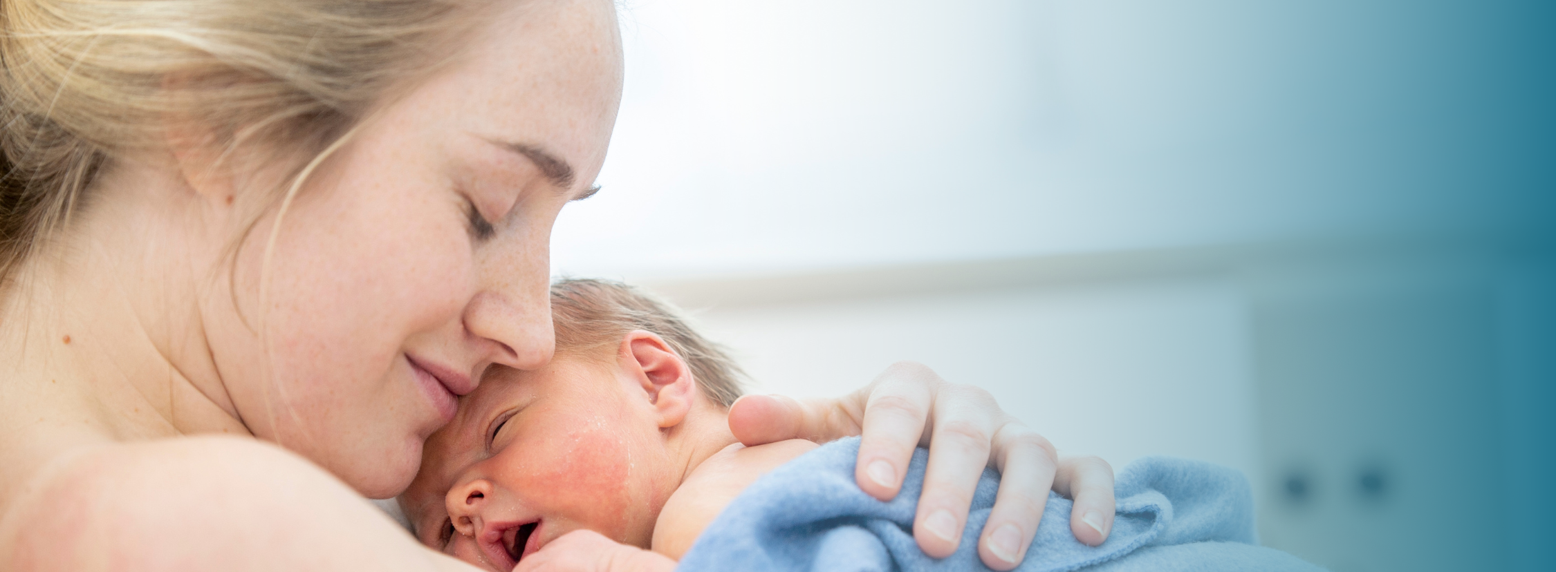 A mother lovingly craddles her newborn baby again her chest.