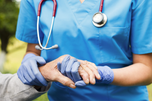 Caregiver holding patient hand