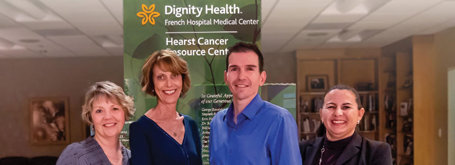 Four Dignity Health employees in front of Hearst Cancer Resource Center sign