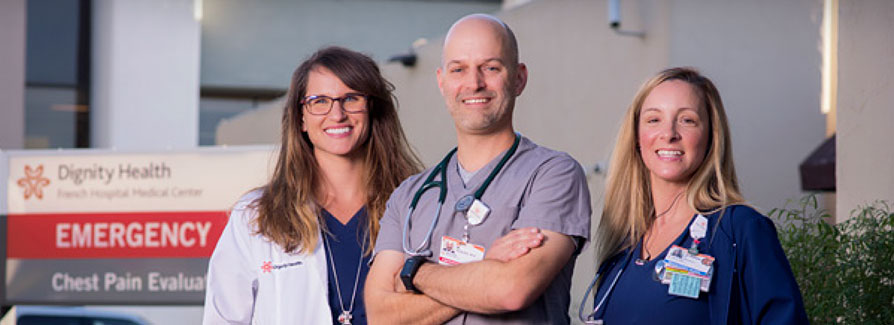 Three Dignity Health employees outside in front of Emergency sign