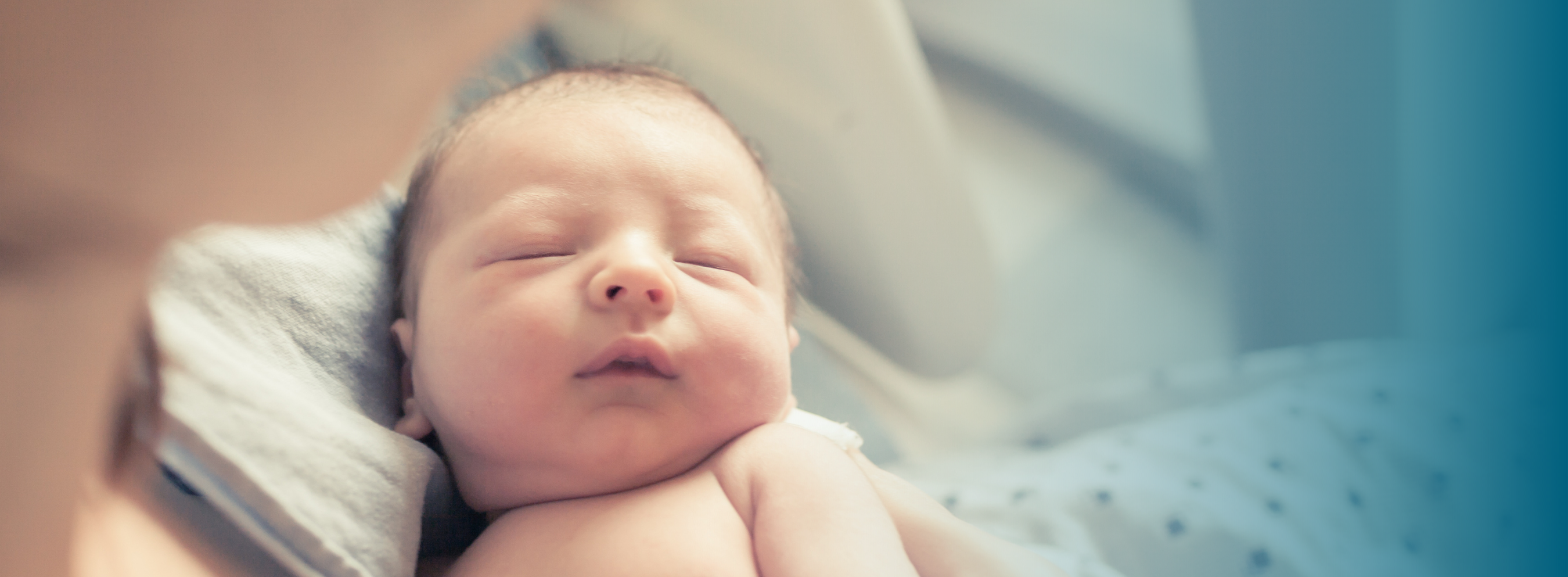 Newborn in hospital with eyes closed.